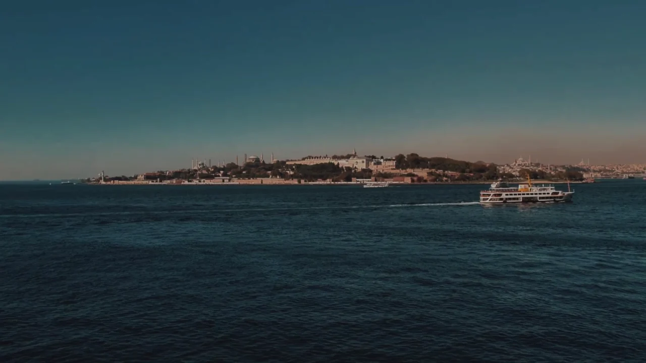 A ferry crossing the Bosphorus at dusk, with the old city on the skyline